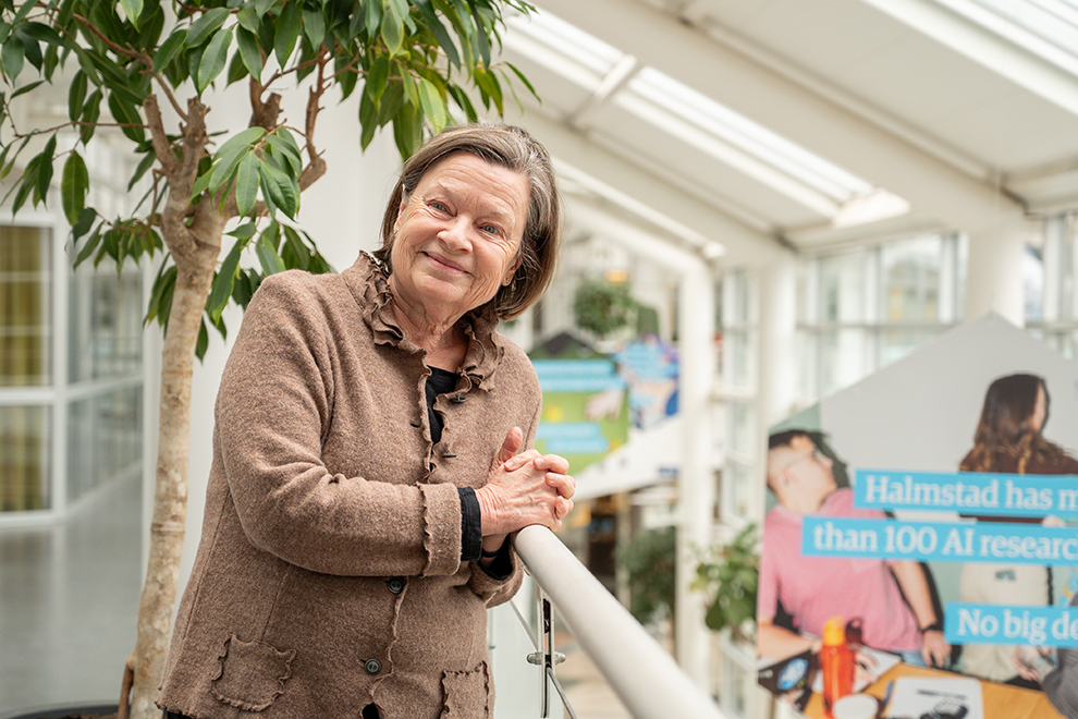 Older woman with brown hair, smiling and looking to the side. Image.