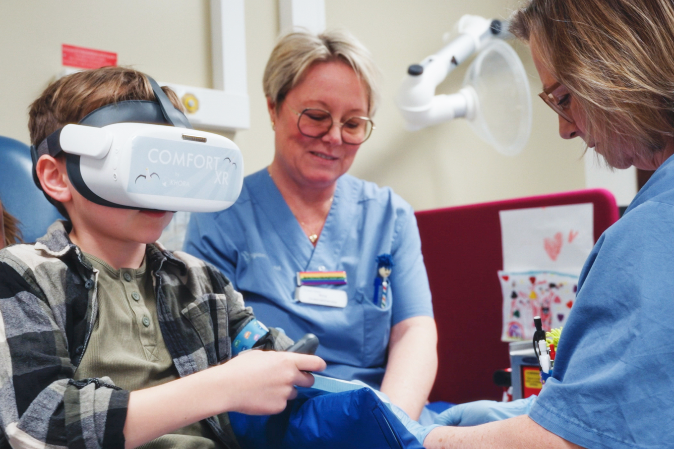 Barn i sjukhusmiljö med VR-set ska till att få en spruta i armen av en sköterska. Bild.
